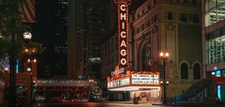 The iconic 'Chicago' marquee lights up the street at night in downtown Chicago.