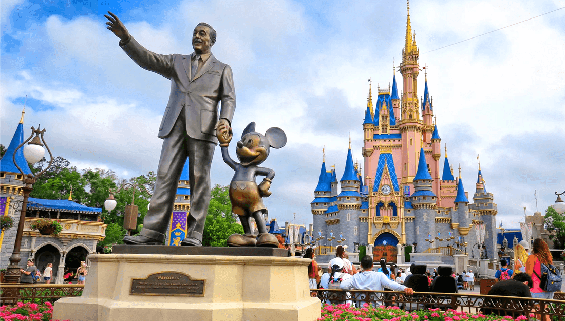 Bronze statue of Walt Disney and Mickey Mouse before Cinderella's Castle at Magic Kingdom.