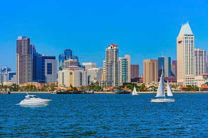 San Diego skyline with boats on blue water under a clear sky.