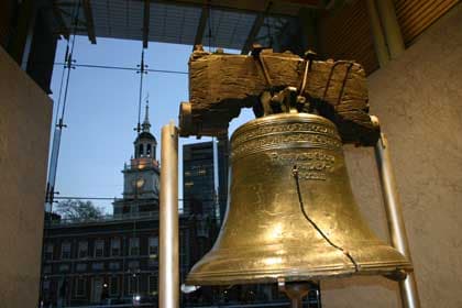 Historic Liberty Bell with its famous crack, showcasing Independence Hall in the background.